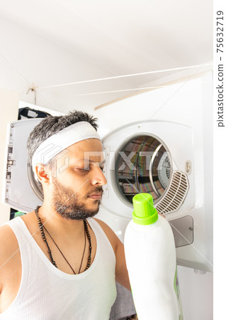 Young man with headband going to wash your dirty laundry 75632719