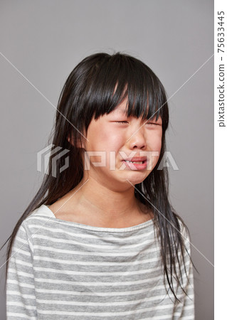 一個可愛的小學女孩的哭泣的表情在工作室拍攝 75633445
