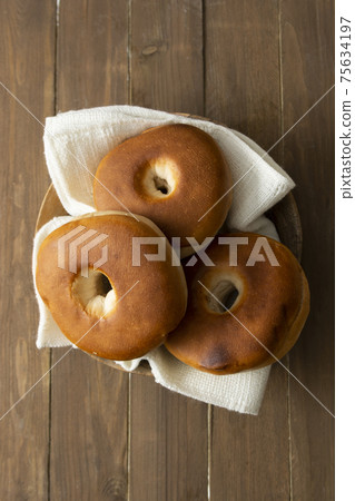Bagels pastry buns for breakfast, sandwich or snack. Top view, wooden table. Bagels pastry buns for breakfast, sandwich or snack. Top view, wooden table. 75634197