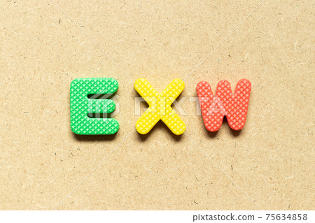 Foam alphabet letter in word EXW (abbreviation of Ex works)  on wood background 75634858