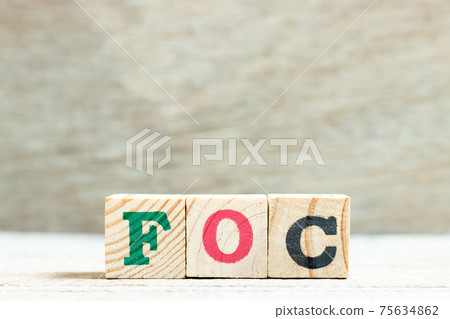 Alphabet letter block in word FOC (Abbreviation of Free of charge) on wood background 75634862