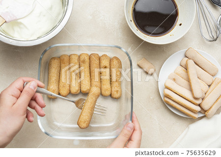 Cooking tiramisu cake with sponge fingers cookies. Step by step recipe. Top view. 75635629