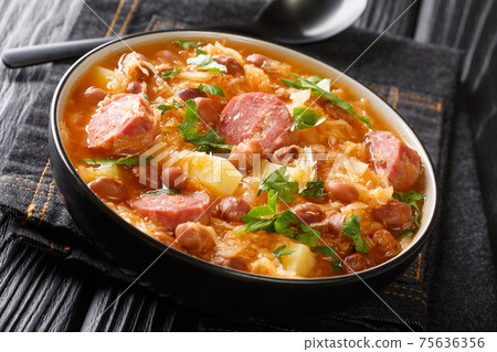 Portion of Jota sauerkraut with borlotti beans, potatoes and sausages close-up in a bowl. horizontal Portion of Jota sauerkraut with borlotti beans, potatoes and sausages close-up in a bowl. horizontal 75636356