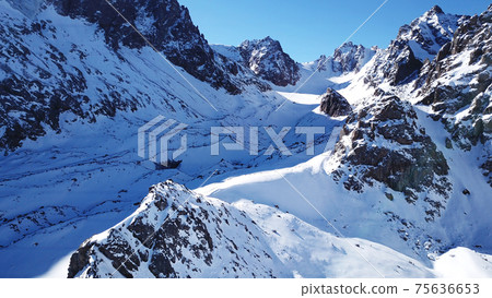 A group of climbers is walking in the mountains. A group of climbers is walking in the mountains. 75636653