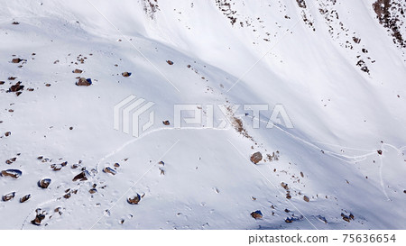 A group of climbers is walking in the mountains. A group of climbers is walking in the mountains. 75636654