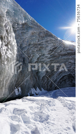 High ice wall in mountains. Bogdanovich Glacier High ice wall in mountains. Bogdanovich Glacier 75636734