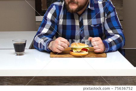 A man with a beard sits and looks at burgers with harmful soda, background, cheeseburger A man with a beard sits and looks at burgers with harmful soda, background, cheeseburger 75636752