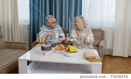 Mature family couple grandfather, grandmother relaxing on cozy sofa enjoying conversation at home Mature family couple grandfather, grandmother relaxing on cozy sofa enjoying conversation at home 75636958