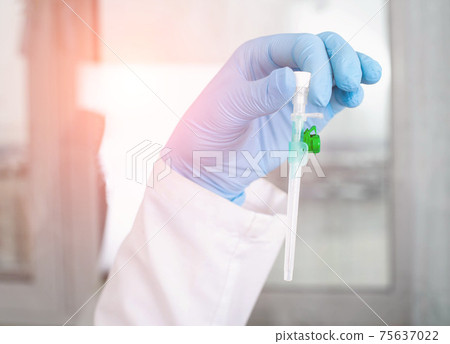 The doctor holds an intravenous catheter in his hand against the background of the laboratory. Blood transfusion concept and blood diagnostics, medical 75637022
