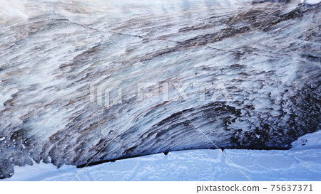 A huge wall of ice. Glacier in the mountains. 75637371