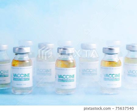 Coronavirus vaccine dose bottles on blue background covered in smoke. Kotsnept developing and testing a new vaccine in the laboratory 75637540