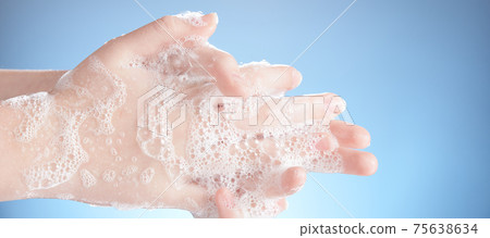 Washing female hands isolated on blue background. Washing female hands isolated on blue background. 75638634