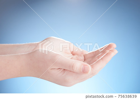 Close-up of beautiful woman hands, palms up. Isolated on blue background. Photo from copy space. Close-up of beautiful woman hands, palms up. Isolated on blue background. Photo from copy space. 75638639