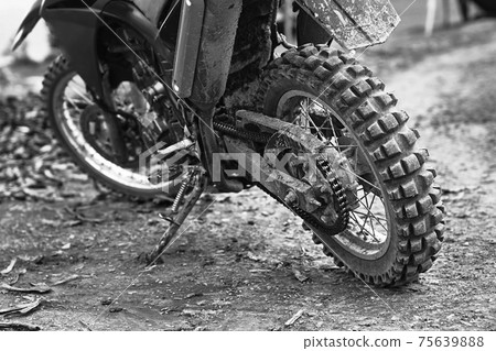 Offroad mountain motorcycle or bike taking part in motocros competition parked on dirty terrain road 75639888