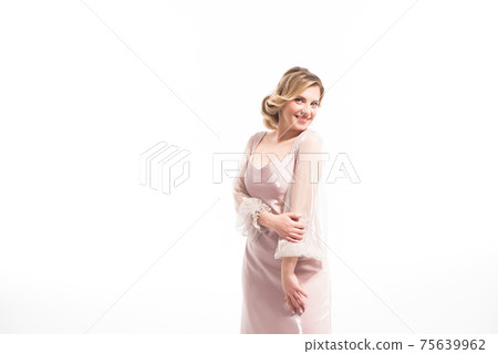 Young woman wearing beige dress posing against white background Young woman wearing beige dress posing against white background 75639962