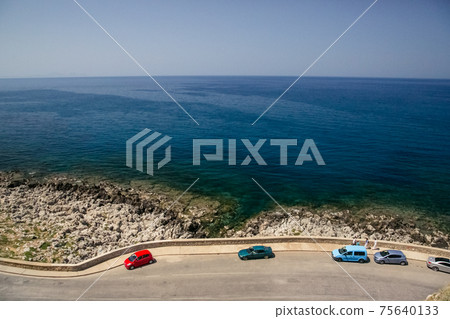 Road cut off the sea and mountains. The blue sea along the way. 75640133