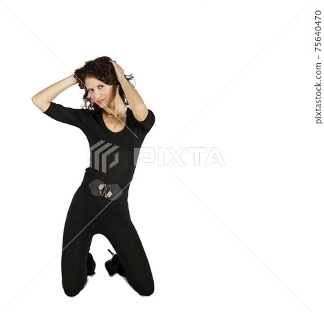 young beautiful woman in black suit posing in studio kneeling 75640470