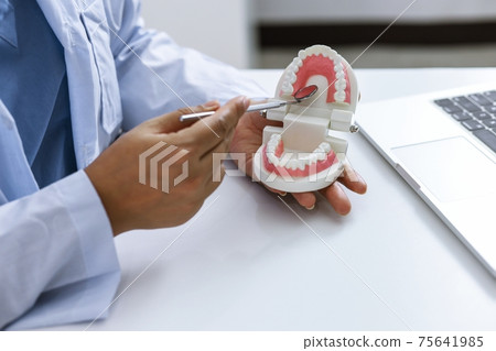 Dentist examining a patient teeth medical treatment at the dental clinic. Dentist examining a patient teeth medical treatment at the dental clinic. 75641985