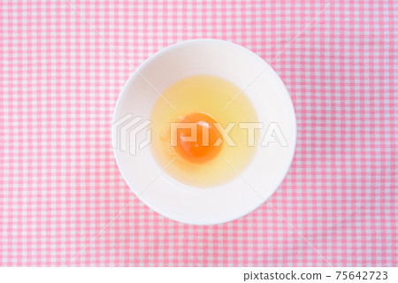 Beautiful raw eggs in a bowl on a place mat Beautiful raw eggs in a bowl on a place mat 75642723