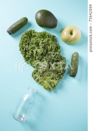 Empty battlle and green vegetables for smoothie. Top view. Empty battlle and green vegetables for smoothie. Top view. 75642894
