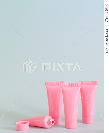 Set of pink cosmetic tubes on gray background close-up Set of pink cosmetic tubes on gray background close-up 75642898
