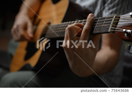 Man playing acoustic guitar, cover for online courses, learning at home. Man playing acoustic guitar, cover for online courses, learning at home. 75643686