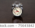 Metal alarm clock on a wooden table 75643842