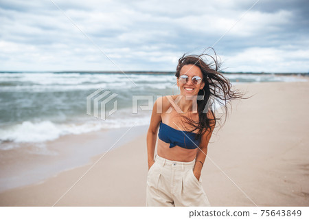 Young happy woman on the beach Young happy woman on the beach 75643849