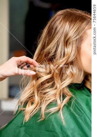 Hairdresser styling hair of woman 75644659