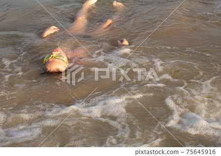Boy 10 years old enjoys swimming in the coastal waves in the sea. Boy 10 years old enjoys swimming in the coastal waves in the sea. 75645916