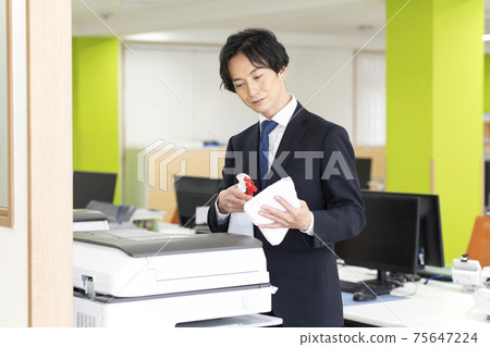 A man who disinfects and cleans a copier (multifunction machine) shared by the company 75647224