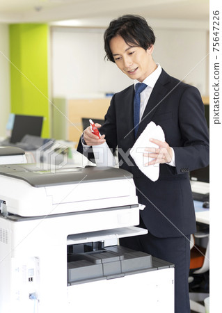 A man who disinfects and cleans a copier (multifunction machine) shared by the company 75647226