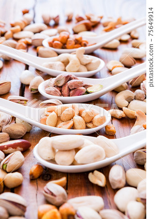 Mix of nuts over a rustic table Mix of nuts over a rustic table 75649914