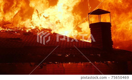 fire close-up. fire on the roof of the house. a burning at building house . home insurance apartment concept. huge fire blazes houses 911. property damage arson protection night fire close-up. fire on the roof of the house. a burning at building house . home insurance apartment concept. huge fire blazes houses 911. property damage arson protection night 75650469