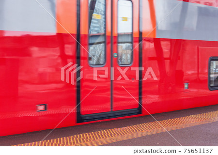 Highspeed train moves fast by the platform. 75651137