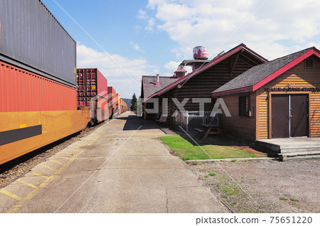 Long freight train moves from Vancouver to Calgary. Lake Louise station. 75651220