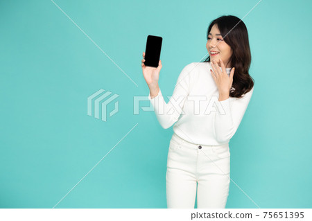 Portrait of beautiful Asian woman showing or presenting mobile phone application on hand isolated over light green background Portrait of beautiful Asian woman showing or presenting mobile phone application on hand isolated over light green background 75651395