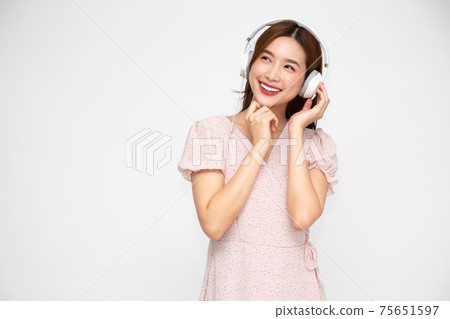 Young Asian woman listening music with headphones isolated on white background Young Asian woman listening music with headphones isolated on white background 75651597