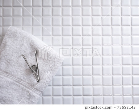 毛巾，不銹鋼衣夾和瓷磚。洗衣店和生活方式的形象。有副本空間。 75652142
