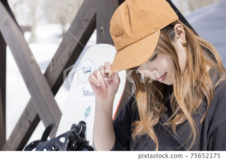Snowboarder woman resting at a ski lodge 75652175