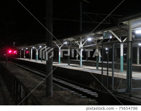 Train station platforms and railroad tracks with red lights at night Train station platforms and railroad tracks with red lights at night 75654786