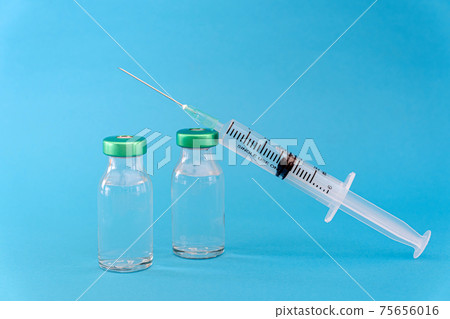 Potential trials stage concept on blue background. Close up Vials with sterile needle syringe. Research and Development, Vaccination. Potential trials stage concept on blue background. Close up Vials with sterile needle syringe. Research and Development, Vaccination. 75656016