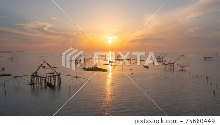 Local fishing trap net in canel, lake or river at sunset. Nature landscape fisheries and fishing tools lifestyle at Pak Pha, Phattalung, Thailand. Aquaculture farming. 75660449