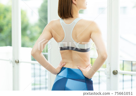 A woman stretching in her room A woman stretching in her room 75661051