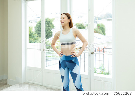 A woman stretching in her room A woman stretching in her room 75662268