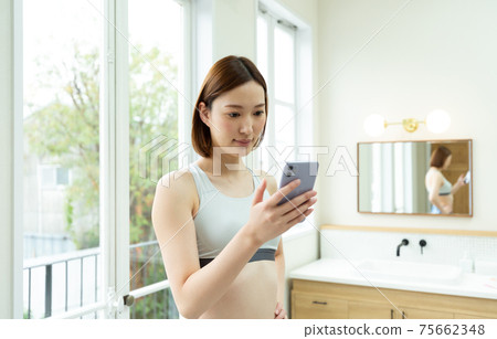 A woman stretching in her room A woman stretching in her room 75662348