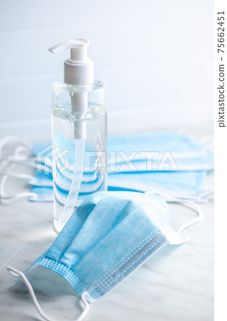 Coronavirus prevention hand sanitizer and medical face mask. Hand disinfectant gel in pump bottle. 75662451