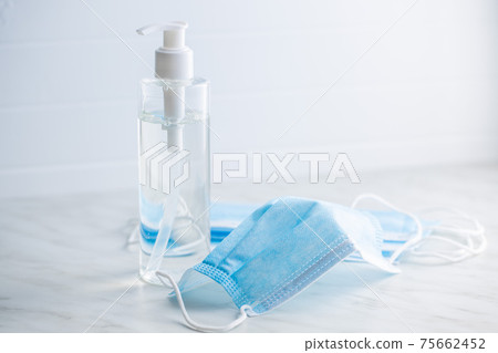 Coronavirus prevention hand sanitizer and medical face mask. Hand disinfectant gel in pump bottle. 75662452