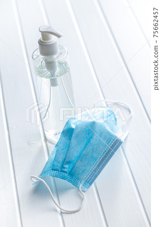 Coronavirus prevention hand sanitizer and medical face mask. Hand disinfectant gel in pump bottle. 75662457