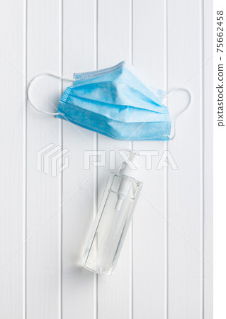 Coronavirus prevention hand sanitizer and medical face mask. Hand disinfectant gel in pump bottle. 75662458